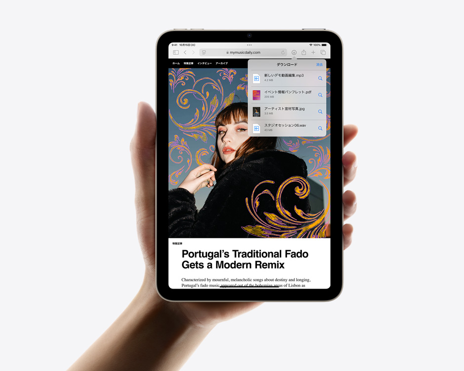 ユーザーがiPad miniを縦向きに片手で持っている。画面にはSafariのダウンロードした項目が表示されている