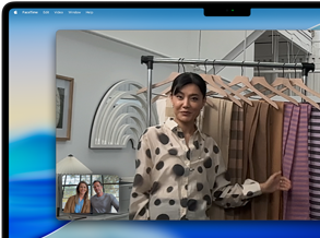 Un apel video pe un MacBook Pro, unde o femeie arată materiale textile către două persoane aflate în apel, cu Scena centrală care o menține centrată în cadru în timp ce ea se mișcă