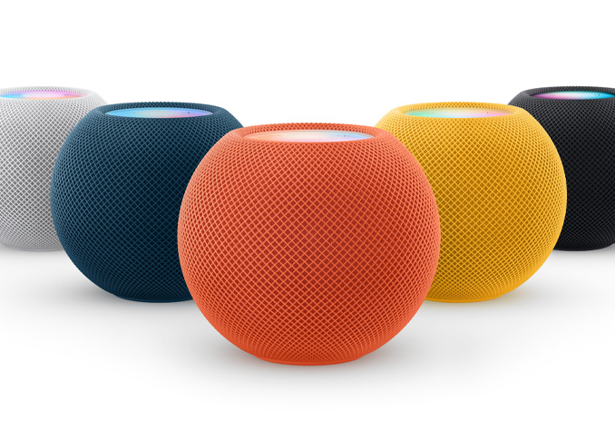 De izquierda a derecha: un HomePod mini blanco, uno azul, uno naranja, uno amarillo y uno color medianoche